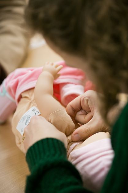 A doll's arm being sewn back on.